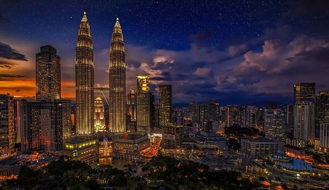Vue nocturne de Kuala Lumpur avec les célèbres tours Petronas illuminées, un incontournable moderne lors d’un voyage en Malaisie - voyage sur mesure avec Nahra Travel, spécialiste Asie et Moyen-Orient.