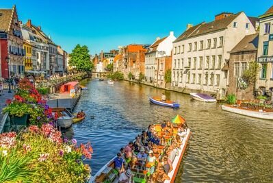 Nahra Travel organisation de voyage sur mesure travel planner Asie Europe Afrique Moyen-Orient - vue d’un canal de Gand en Belgique bordé de maisons historiques colorées et de bateaux touristiques.